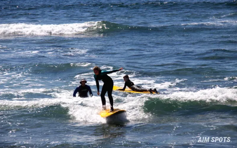 beginner surfer on a soft top board at the beach