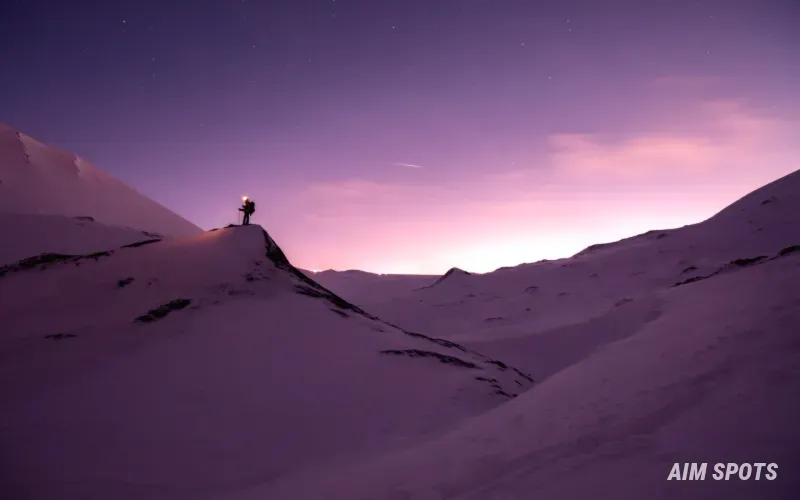 hiker in snowy mountain terrain with gear